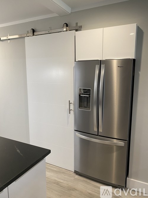 A stainless steel refrigerator with a water and ice dispenser in the middle of the door.