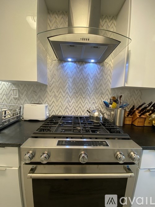 A modern kitchen with a stove top oven and a range hood.