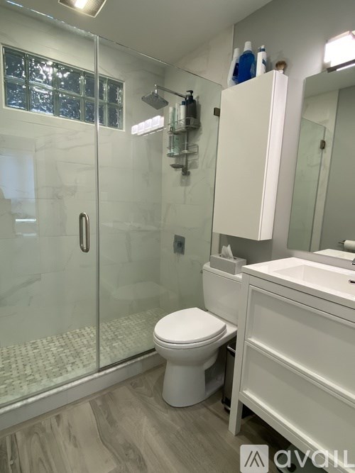 A white toilet in a bathroom with a glass shower door.