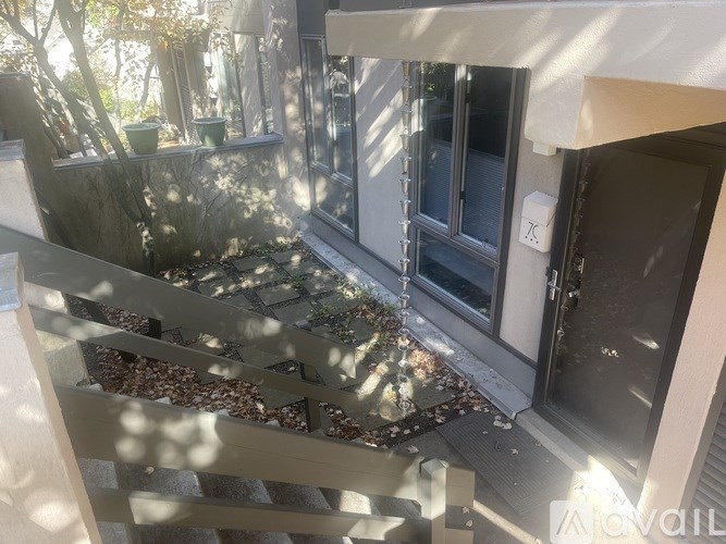 A staircase with a glass railing and a tree in the background.