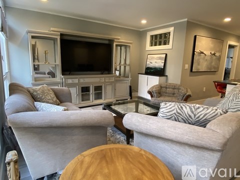 A living room with a grey couch and a wooden table.