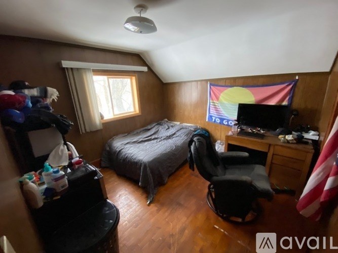 A room with a bed, desk, and chair.