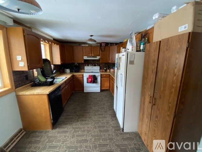 A kitchen with a white fridge and wooden cabinets.