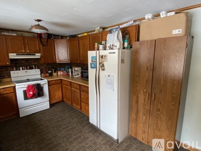 A kitchen with a white fridge and wooden cabinets.
