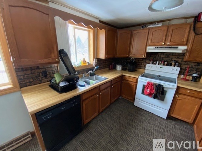 A kitchen with wooden cabinets and a white stove top oven.