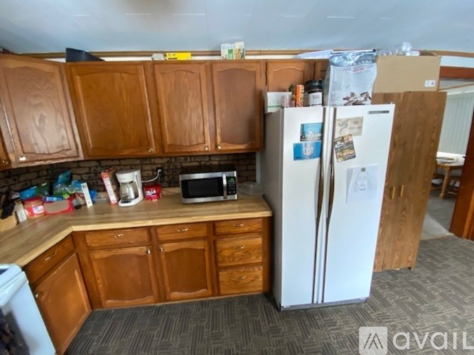 A kitchen with wooden cabinets and a white fridge.