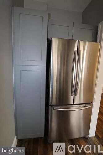 A stainless steel refrigerator with two doors is in a kitchen.