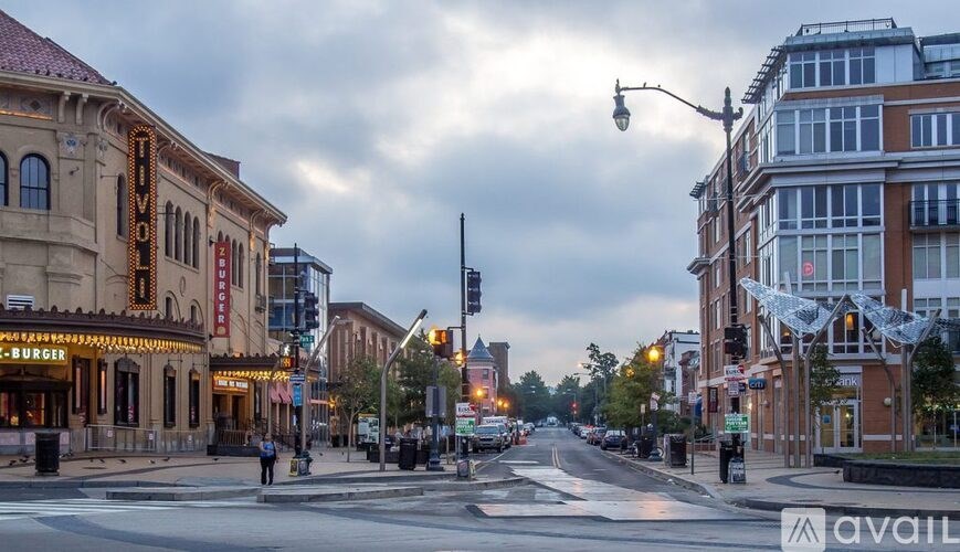 A street view of a city with a theater and buildings on either side.