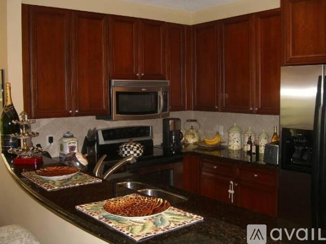 A kitchen with wooden cabinets and a black refrigerator.