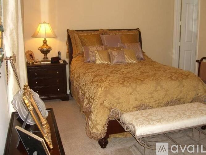 A bedroom with a bed, nightstand, and lamp.