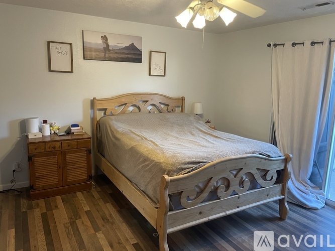 A bedroom with a large bed and wooden flooring.