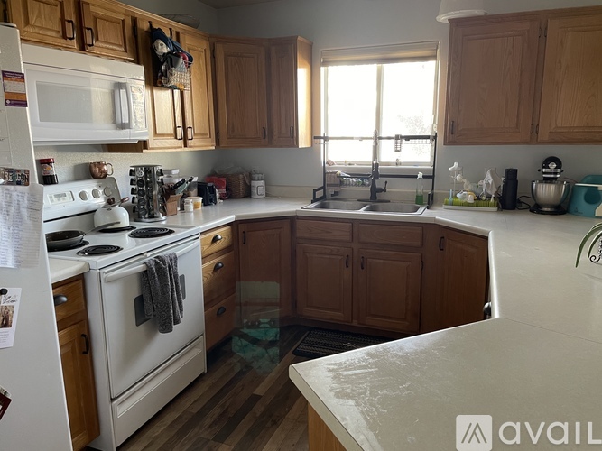 A kitchen with wooden cabinets and a white stove top oven.