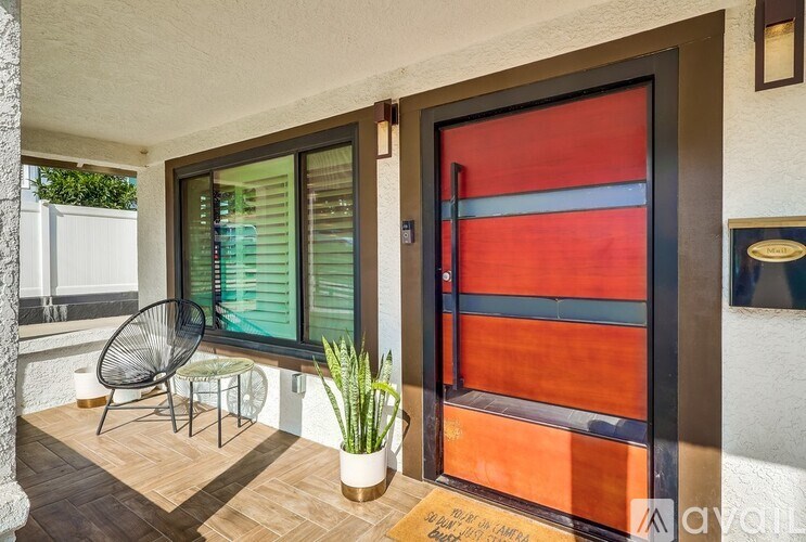 A patio with a chair, table, and potted plant.