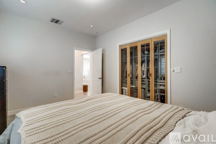 A bedroom with a large bed and a sliding door.