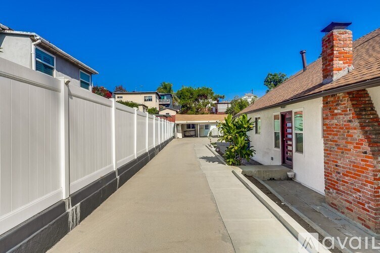 A long white fence runs down the side of a building.