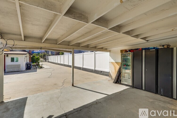 A parking garage with a concrete floor and a concrete ceiling with a metal beam.