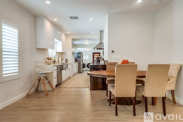 A modern kitchen with a dining table set up with chairs.