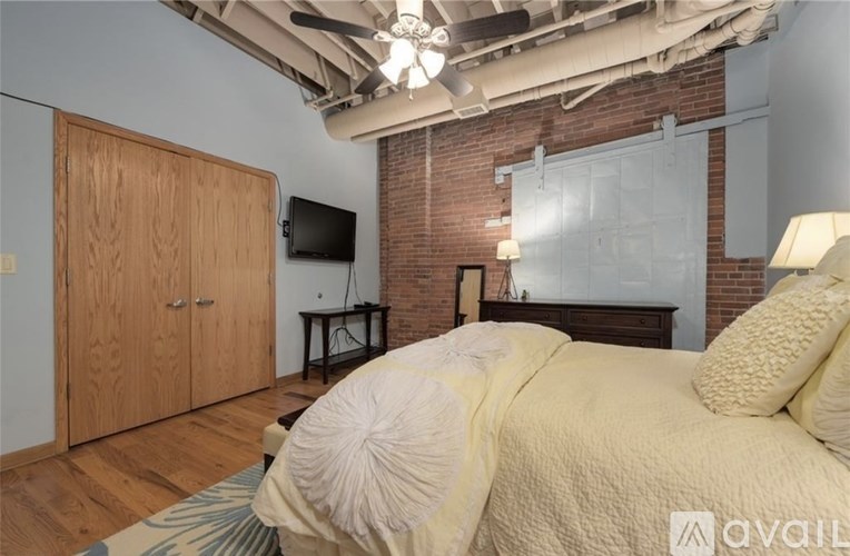 A bedroom with a bed, a dresser, and a television.