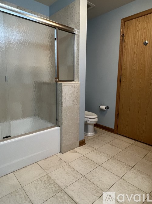 A bathroom with a toilet and a shower stall.