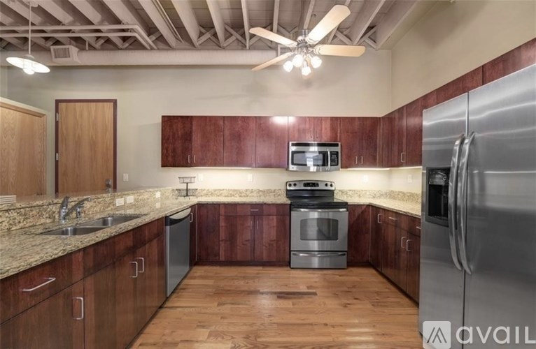 A kitchen with wooden cabinets and a stainless steel refrigerator.