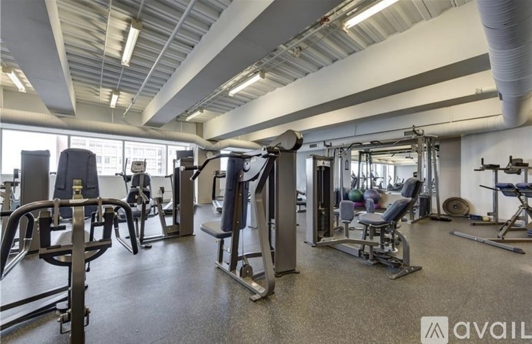 A gym with a variety of equipment including treadmills, weights, and exercise machines.
