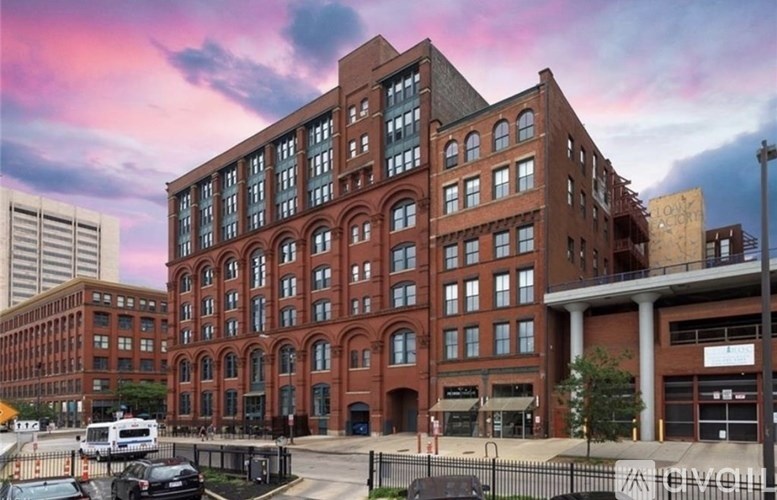 A large red brick building with a parking lot in front.