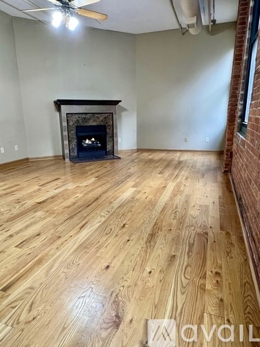 A room with a fireplace and wooden flooring.
