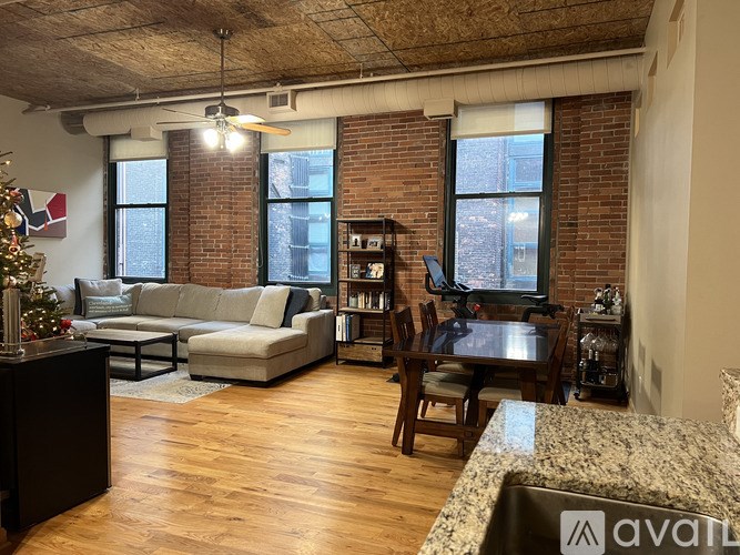 A living room with a Christmas tree and a kitchen area with a sink.