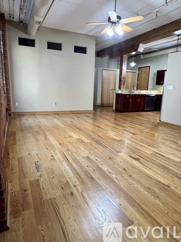 A room with wooden flooring and a ceiling fan.