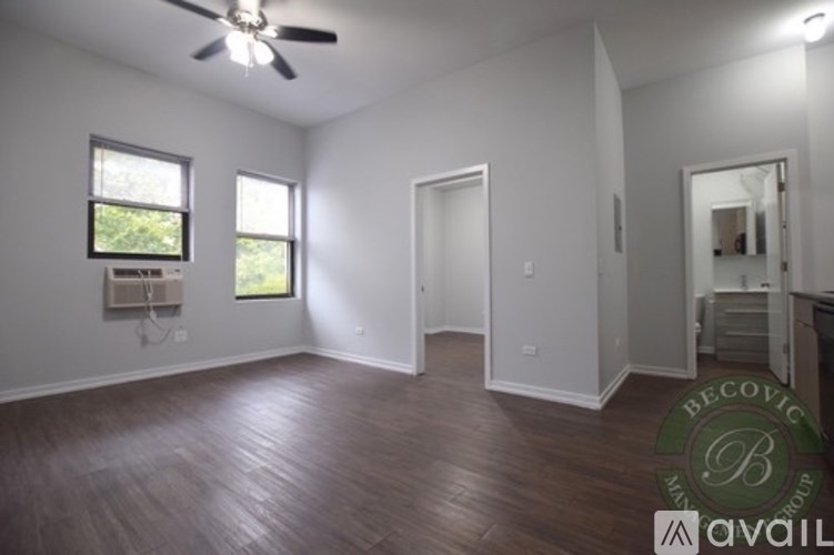 A room with a ceiling fan and wooden flooring.