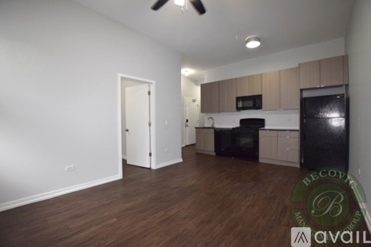 A kitchen with a black fridge and white cabinets.