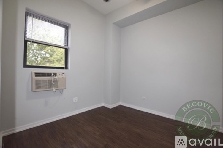 A room with a window and a wall-mounted air conditioner unit.
