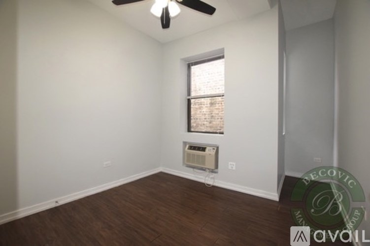 A room with a ceiling fan and a window with blinds.