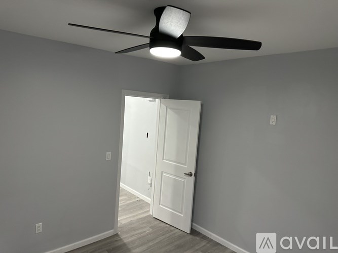 A room with a ceiling fan and a door.
