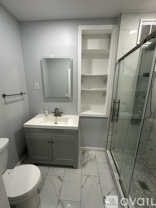 A bathroom with a toilet, sink, and shower.