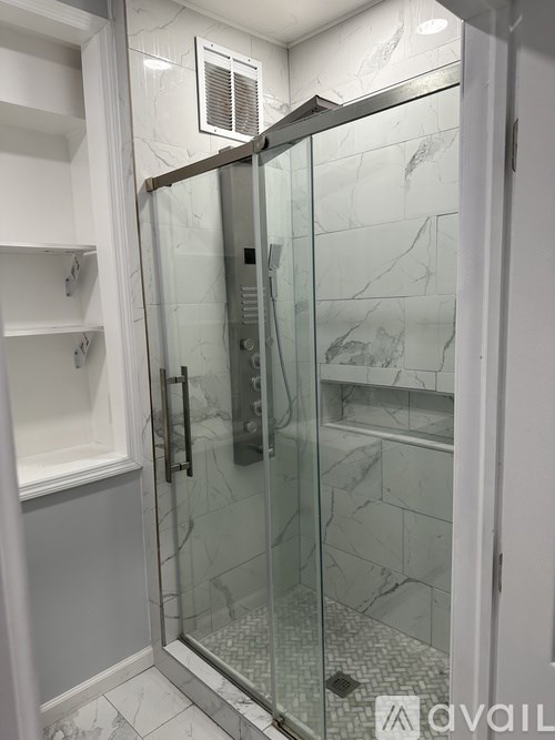A glass shower door in a bathroom.