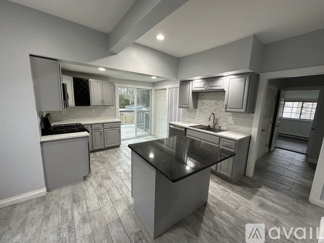 A modern kitchen with a central island and a view of the backyard.