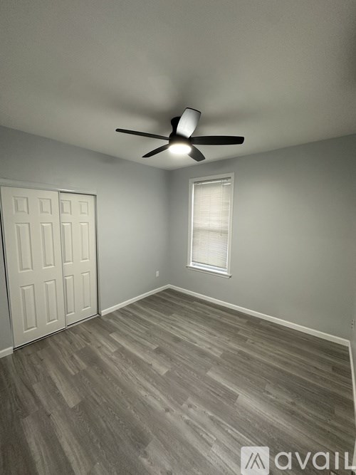 A room with a ceiling fan and a door.