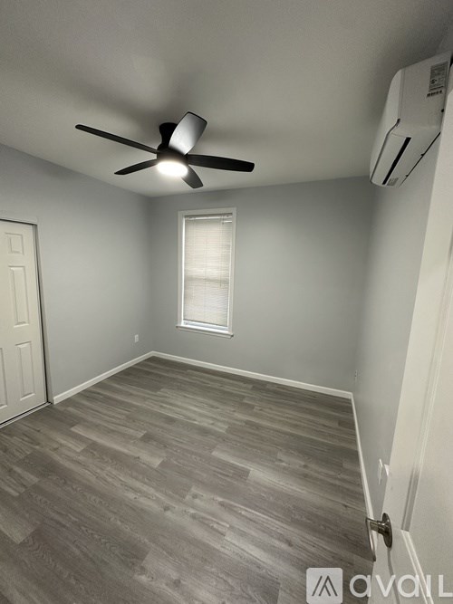 A room with a ceiling fan and a window with blinds.