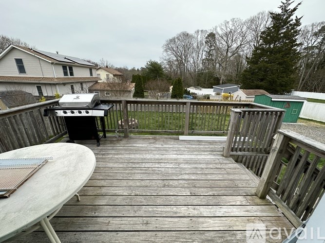 A wooden deck with a grill and picnic table.