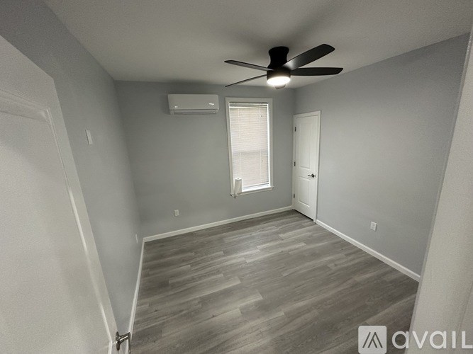 A room with a ceiling fan and a window with blinds.