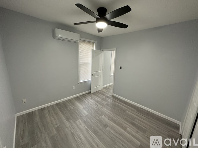 A room with a ceiling fan and wooden flooring.