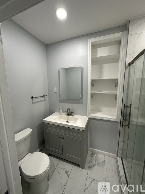 A bathroom with a toilet, sink, and shower.