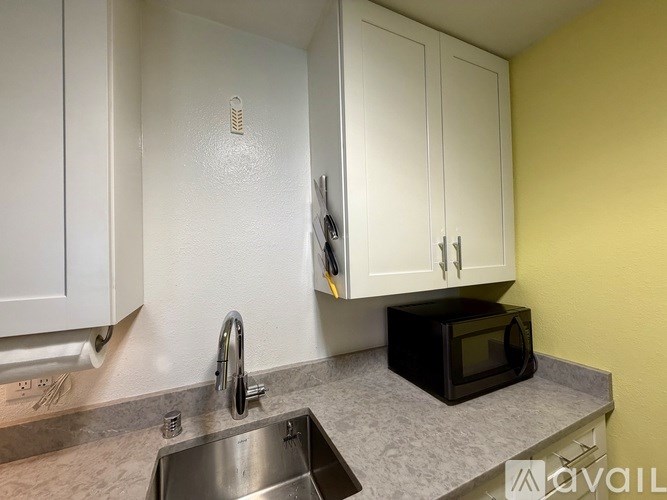 A kitchen with a black microwave on the counter.
