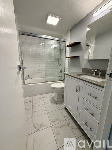 A white bathroom with a walk-in shower and a toilet.