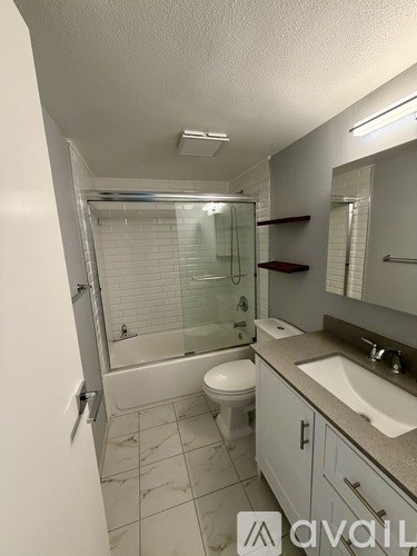 A bathroom with a toilet, sink, and shower.