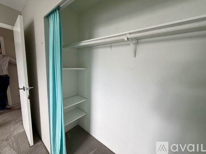A room with a white door and a white shelving unit.