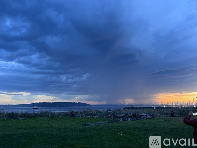 A person is taking a photo of a cloudy sky at sunset.