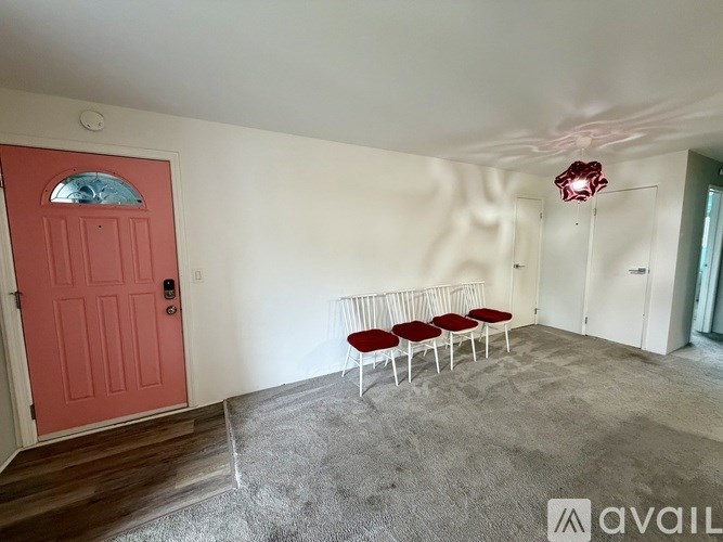 A room with a red door and a row of red chairs.