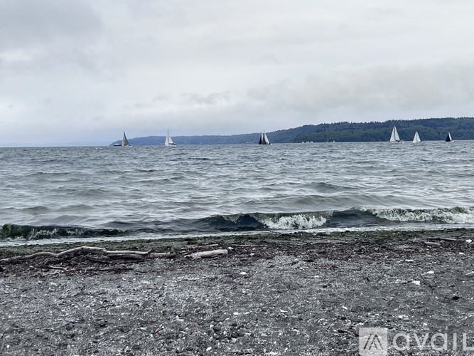 A beach scene with boats in the water and a cloudy sky.
